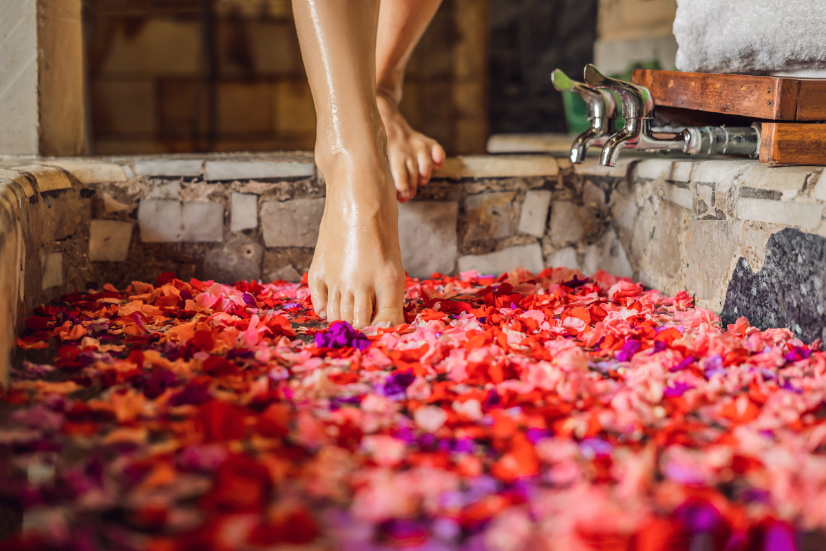 Woman Stepping into a Tub Filled with Flowers 